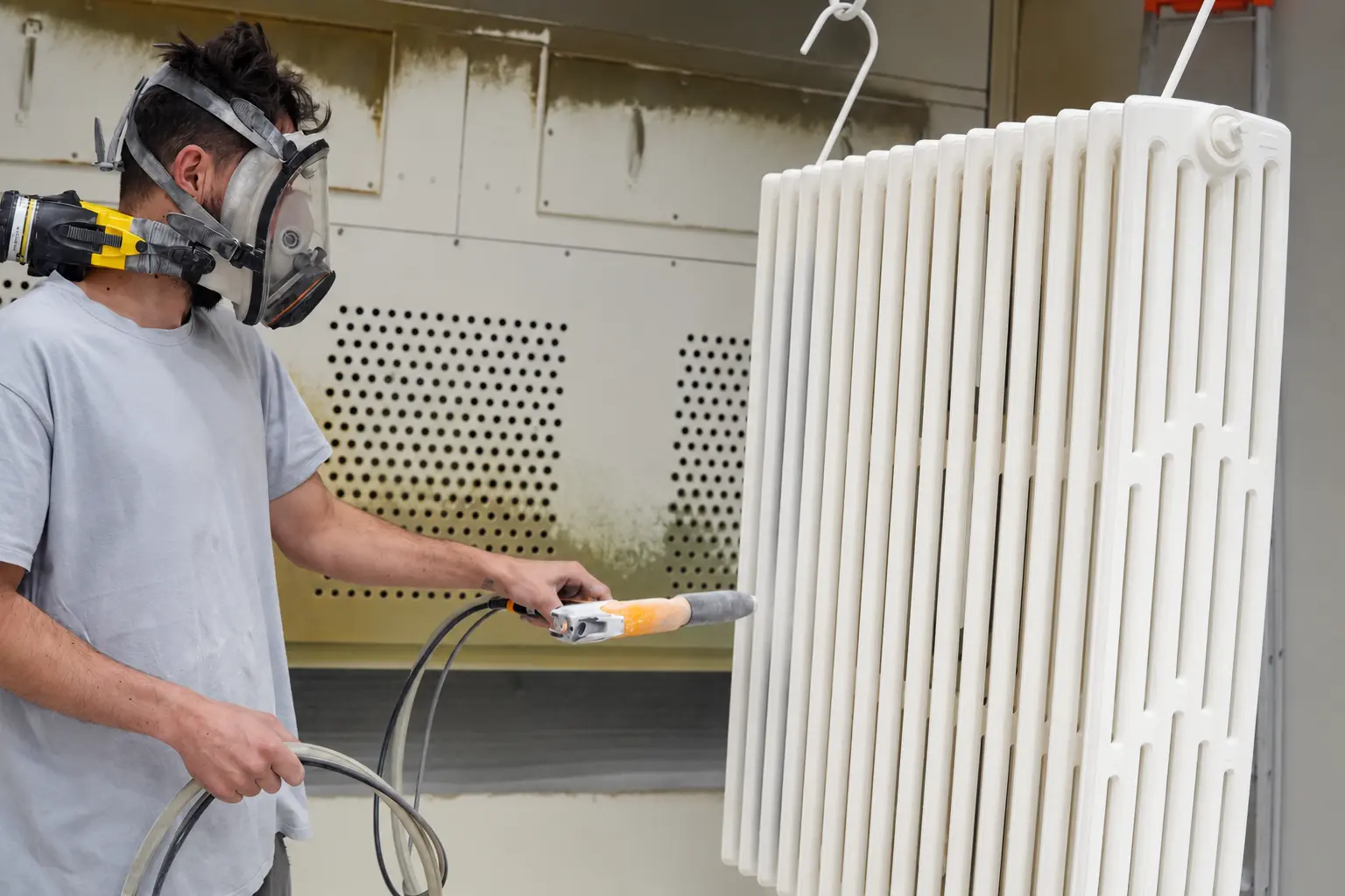 Application de peinture sur un radiateur en fonte dans l’atelier SMP