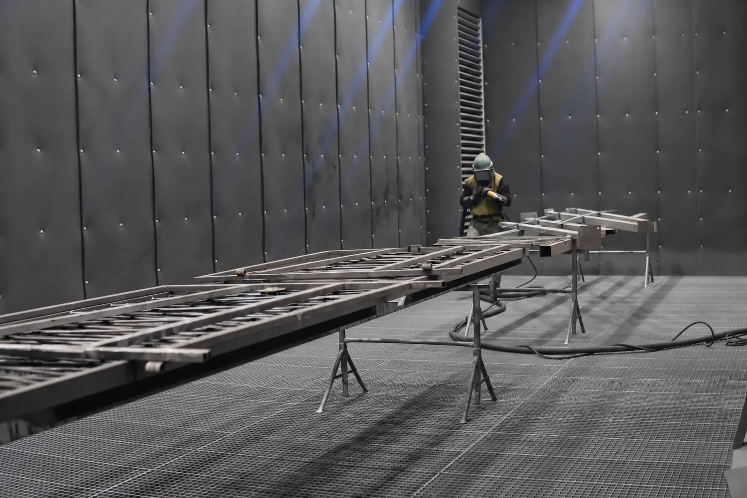 Opérateur réalisant le sablage d’un ouvrage métallique dans la cabine SMP